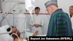 Afghan President Hamid Karzai visits blast victims in Kabul on December 7.