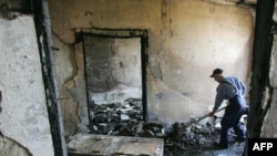 A worker clears debris left by protesters inside the parliament building in Chisinau.