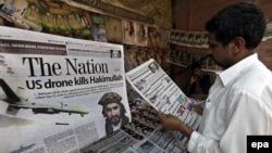 A man in Peshawar on November 2 reads newspapers carrying front-page headlines of the death of Hakimullah Mehsud.