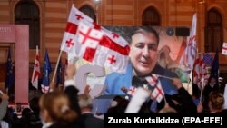 Former Georgian President Mikheil Saakashvili addresses supporters via videolink at a preelection rally in Tbilisi on October 29.