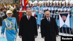 Russian President Vladimir Putin (right) and his Turkish counterpart, Recep Tayyip Erdogan, review an honor guard during a welcoming ceremony in Ankara on December 1.