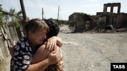 Two women hug each other amid ruins in the South Ossetian capital of Tskhinvali, which was devastated by the brief Georgian-Russian conflict in 2008. 