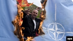 Protesters burn a NATO flag while Montenegro's parliament discusses the ratification of a NATO membership agreement in Cetinje in April.