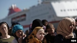 Refugees and migrants wait to receive food distributed by the Greek Red Cross at the port of Piraeus, near Athens. (file photo)