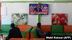 Customers watch a live broadcast of U.S. President Donald Trump speaking during election night at a juice shop in Kabul on November 4.