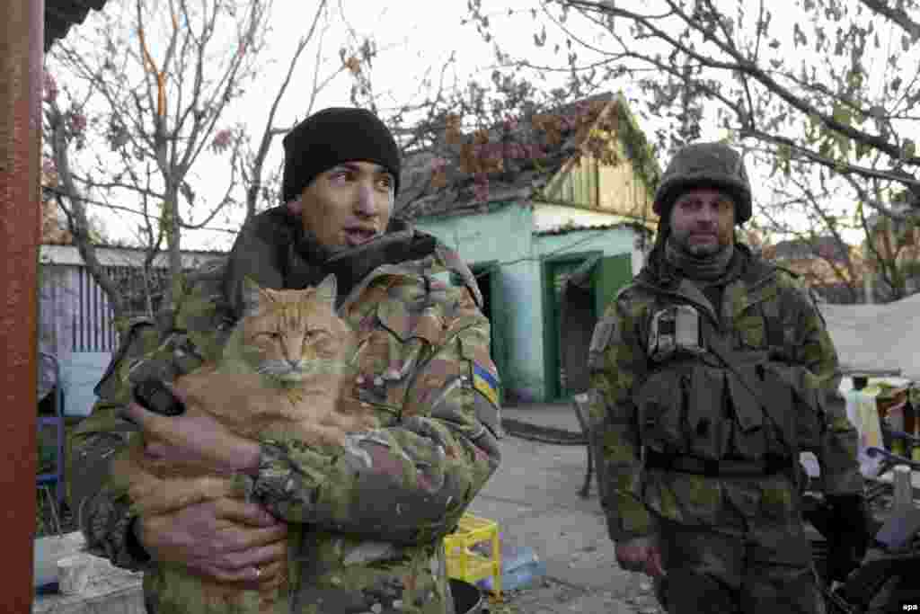 Ukrainian serviceman play with a cat during a short break in the village of Pesky, not far from the embattled airport of Donetsk, in October 2014.