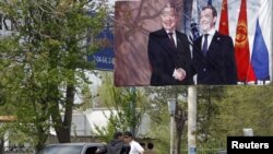 A billboard in southern Kyrgyzstan shows Russian President Dmitry Medvedev (right) with Kurmanbek Bakiev, who fled into exile after a bloody crackdown on protesters in April.