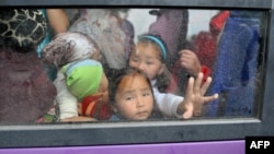 Children in Osh look out the window of a bus as they wait for evacuation to Bishkek on June 17.