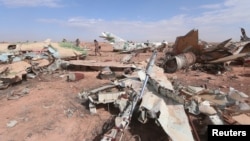 A Syrian Democratic Forces (SDF) fighter walks near destroyed airplane parts inside Tabqa military airport after it was taken from Islamic State fighters on April 9.