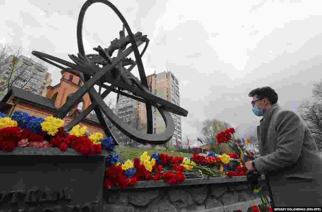 Ukrainians lay flowers near a monument in Kyiv honoring those who died in cleanup efforts after the Chernobyl nuclear disaster.