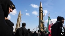 Supporters of the Islamic republic march past ballistic missile models in Tehran during the 46th anniversary of the Islamic revolution, February 10