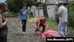 A father approaches the body of his son who was reportedly killed by a Russian cluster rocket in the city of Lysychansk in eastern Ukraine on June 18.