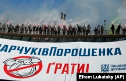 Volunteers with the right-wing paramilitary Azov National Corps brandish flares atop a big banner reading "The Svinarchuks of Poroshenko in jail!" at a protest rally in central Kyiv on March 2.