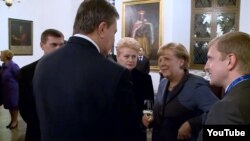 German Chancellor Angela Merkel, glass in hand, had an awkward exchange with Ukrainian President Viktor Yanukovych (center, back to camera) on the first day of the Third Eastern Partnership Summit in Vilnius on November 28.