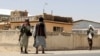 Taliban fighters stand guard in the city of Ghazni on August 13.