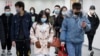 People wearing protective masks in a subway tunnel during evening rush hour in Beijing on March 10.