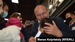 Raqyzhan Zeinolla embraces his granddaughter for the first time at the airport in Almaty on April 9.