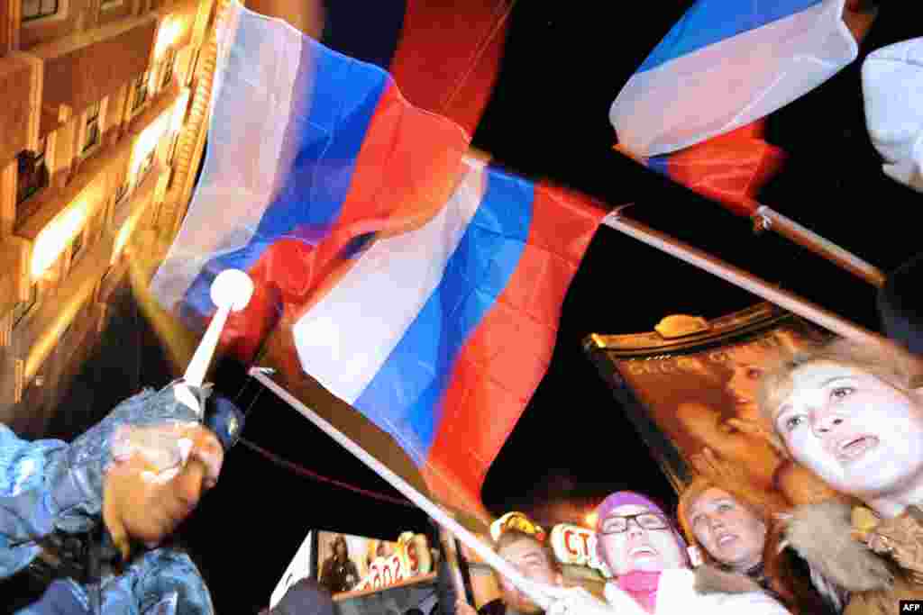 Activists of pro-Kremlin youth movements wave the Russian flag as they rally in Moscow.