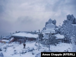 A Buddhist carries firewood past the main building of the Shad Tchup Ling monastery, the building at the heart of the feud, in December 2016.