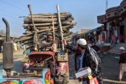 An Afghan refugee at a camp in Peshawar, Pakistan, distributes sweets to celebrate the "reduction in violence" in Afghanistan as part of a peace deal last month.