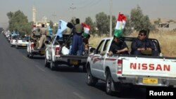 A military convoy drives towards Kirkuk, to reinforce Kurdish troops in Kirkuk on June 24.