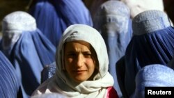 A young Afghan woman shows her face in public for the first time after five years of Taliban rule in November 2001. Does the Koran really call for such standards of decency for women?