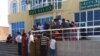 People wait outside a Western Union branch in Turkmenistan. Money transfers abroad in the Central Asian country of some 5.8 million are primarily carried out by Western Union shops located inside official bank premises, which operate under strict government control. (file photo)