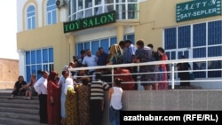 People wait outside a Western Union branch in Turkmenistan. Money transfers abroad in the Central Asian country of some 5.8 million are primarily carried out by Western Union shops located inside official bank premises, which operate under strict government control. (file photo)