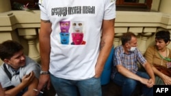 A supporter of the punk group Pussy Riot wears a T-shirt with their pictures and reading "Virgin Mary, drive Putin out!" near a court building in Moscow where they were tried in mid-August.