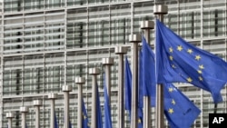 EU flags fly at European Commission headquarters in Brussels.