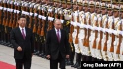 Russian President Vladimir Putin (right) reviews a military honor guard with Chinese President Xi Jinping during a welcoming ceremony outside the Great Hall of the People in Beijing on June 8.