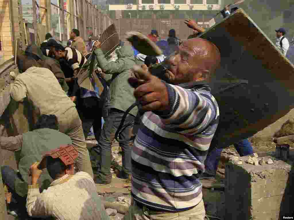 A rock flies past an opposition supporter during rioting against pro-Mubarak demonstrators near Tahrir Square.