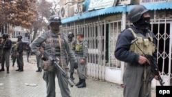 Afghan security officials inspect the scene of a suicide bomb attack in Kabul on February 26