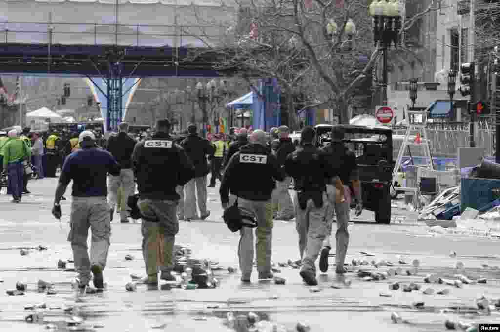 Public safety officials evacuate the scene after the explosions.