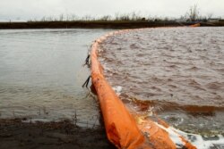 A floating dam is installed to limit the spread of pollution in the Ambarnaya River outside Norilsk after the oil spill there late last month.