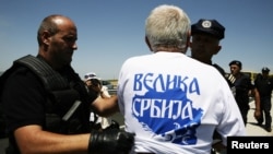 Police detain a Serb wearing a T-shirt reading "Greater Serbia" during a celebration of the anniversary of the 1389 Battle of Kosovo Polje at Gazimestan on June 28.