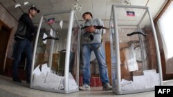 Armed pro-Russian activists stand guard near ballot boxes during the referendum called by pro-Russian rebels to split from the rest of Ukraine on May 11 in Donetsk. 