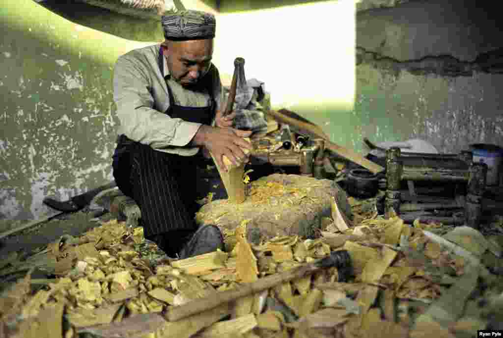 Many Kashgar residents live traditional lives. Here, a man crafts Uyghur instruments. - It’s unclear what will remain of the design and way of life of the city following an ambitious government redevelopment plan.