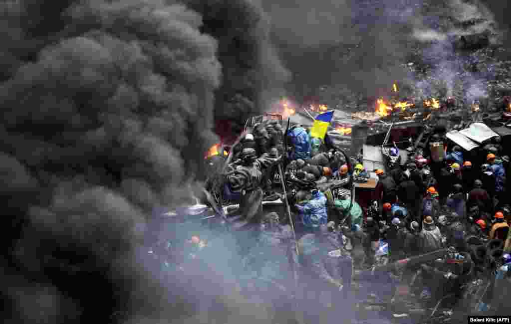 Protesters stand behind burning barricades during a face-off against police in Kyiv on&nbsp;February 20.