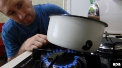 A man cooks on a gas stove in Donetsk, Ukraine.