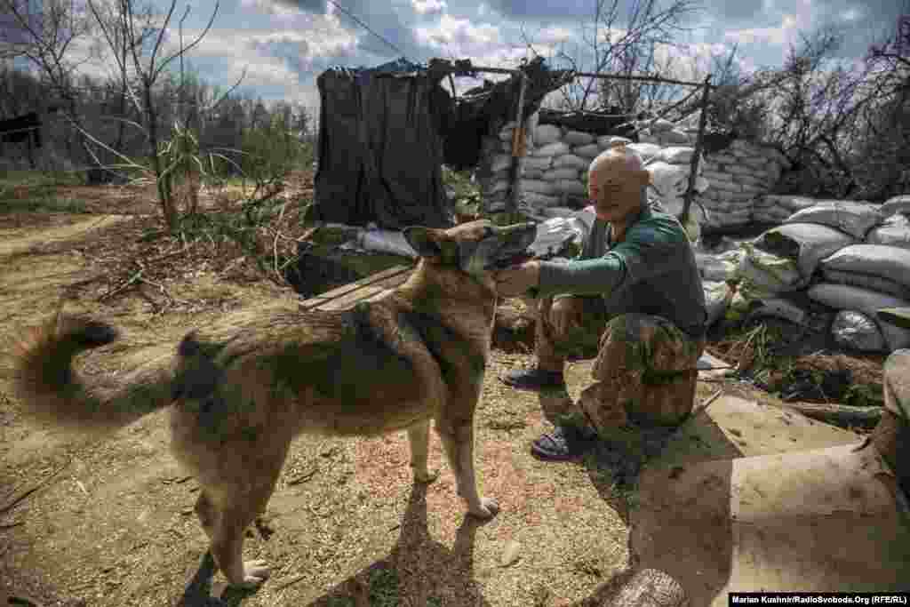 ​Uncle Misha, a Ukrainian soldier, rests before reporting for duty. It is common for the troops on the front lines to keep cats and dogs as pets.