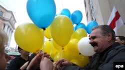 Belarusian opposition protesters share blue and yellow balloons to show their solidarity with Ukraine, during a rally marking the unofficial Freedom Day in Minsk on March 25. 