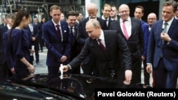 Russian President Vladimir Putin signs a car hood during the opening ceremony of a Mercedes Benz automobile assembly plant outside Moscow on April 3.