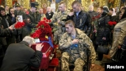 Ukrainian servicemen stand near a coffin containing the body of Ihor Branovytskiy during a funeral service in Kyiv on April 3.