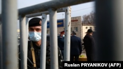 A law enforcement officer at a checkpoint on the outskirts of Almaty on March 19, after authorities locked down the city to contain the spread of the coronavirus. 