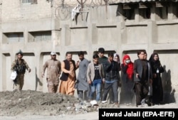 An Afghan soldier escorts rescued TV journalists after militants attacked the Shamshad TV station in Kabul in November.