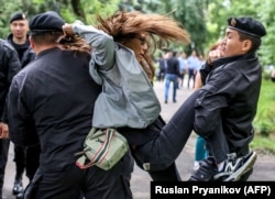 Police officers detain an opposition supporter in Almaty on June 10, 2019, the day after Kazakhstan's presidential election.