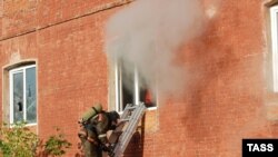 A firefighter stands on a ladder by a window of a garment factory on fire in the town of Yegoryevsk, southeast of Moscow, on September 11.