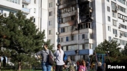 Residents assess the aftermath of a Russian drone strike in the city of Chornomorsk in Ukraine's southern Odesa region on October 8.