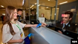 A Moldovan woman presents her passport at the Athens International Airport.